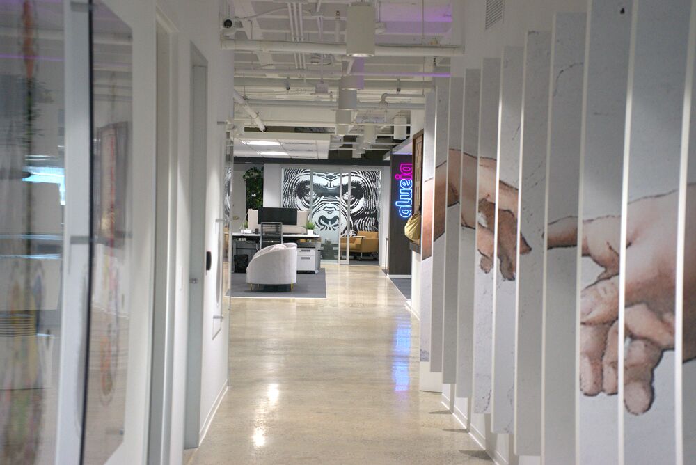 A bright gallery hallway lined with art panels, the gorilla mural at the far end